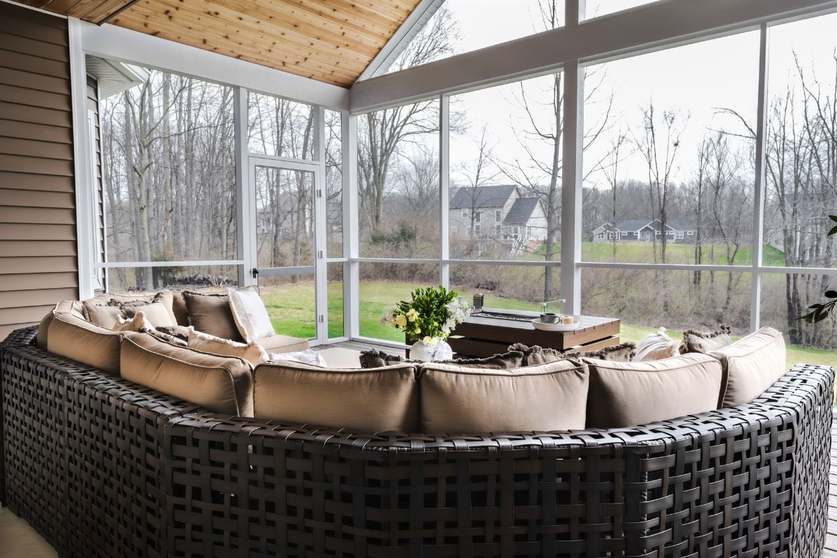 sunroom addition near Triangle Lake Howell Michigan built by Custom Built Design and Remodeling with trex composite decking and fire table