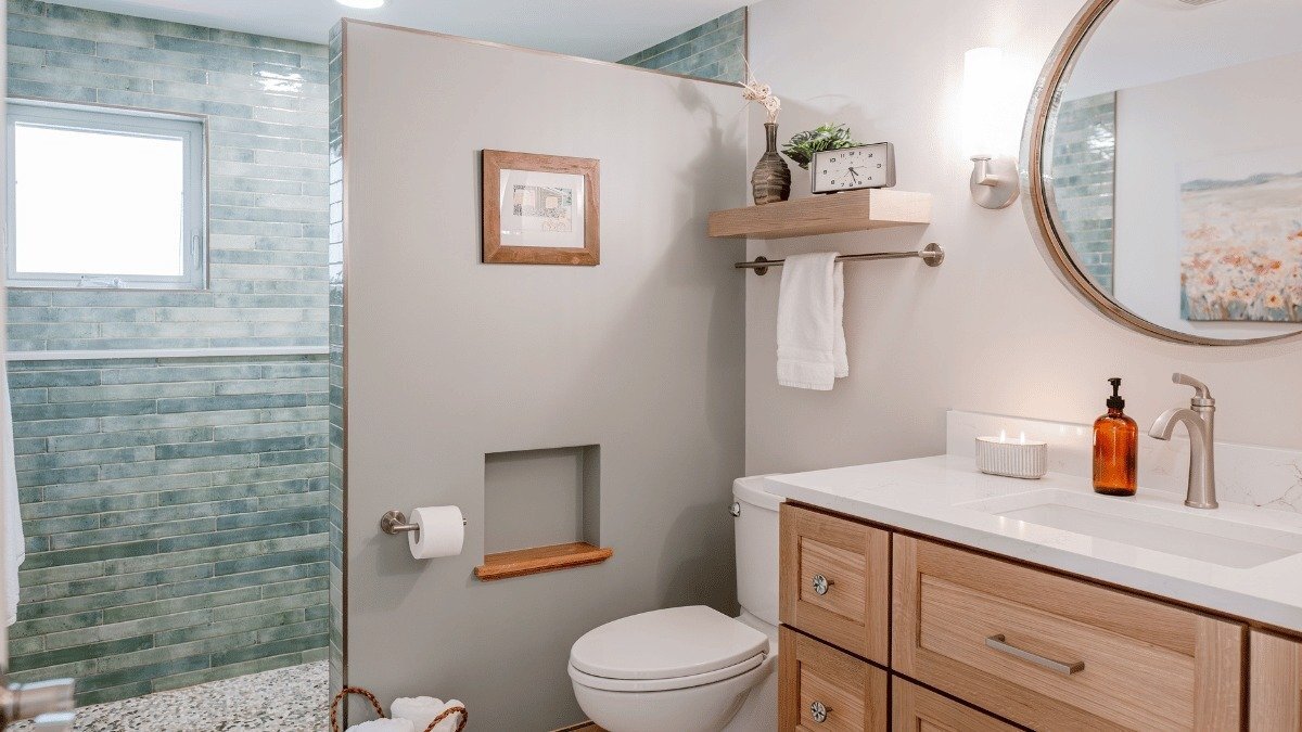 bathroom remodeling project in Riverside Park Lansing Michigan built by Custom Built Design and Remodeling with circular vanity mirror and luxury shower tiles