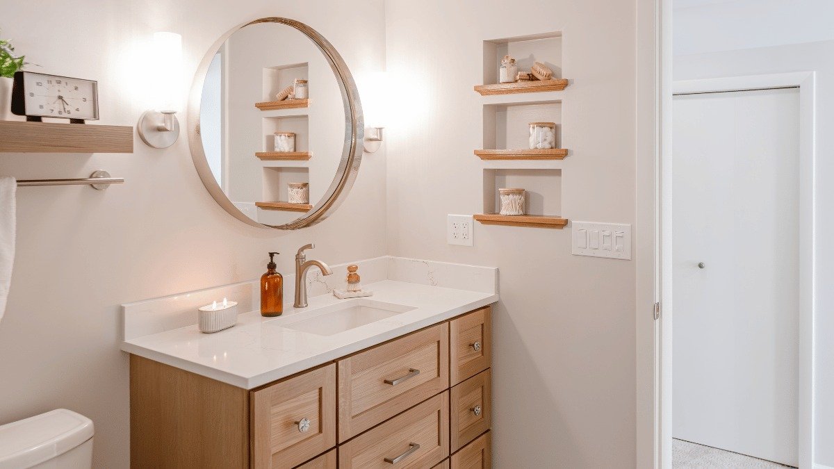 bathroom remodeling project in Riverside Park Lansing Michigan built by Custom Built Design and Remodeling with circular vanity mirror and built in shelving
